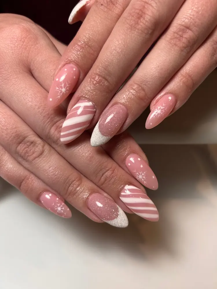 Soft pink almond nails with white candy-cane stripe accents